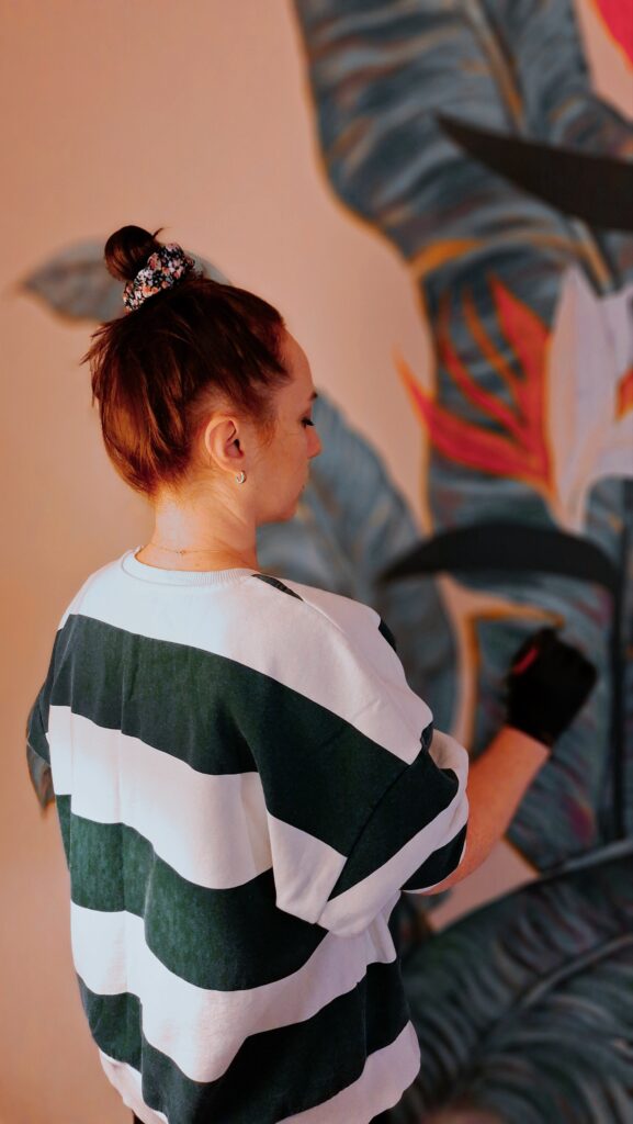 Lana Vender painting a floral wall artwork